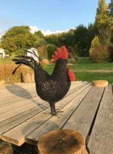 Création en maille grillagée, a la forme d'un coq noir